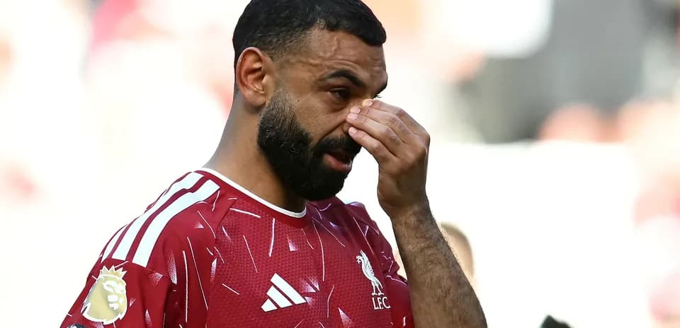 Jugador de Liverpool tocándose la cara durante partido