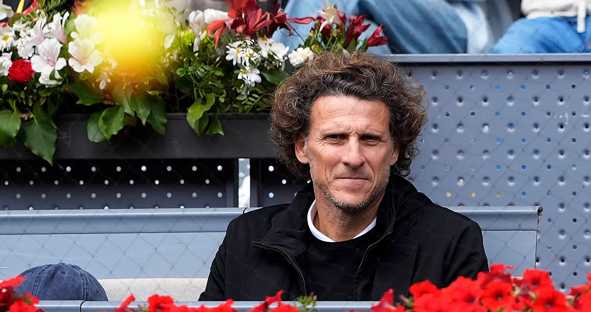 Hombre sentado entre flores en evento deportivo