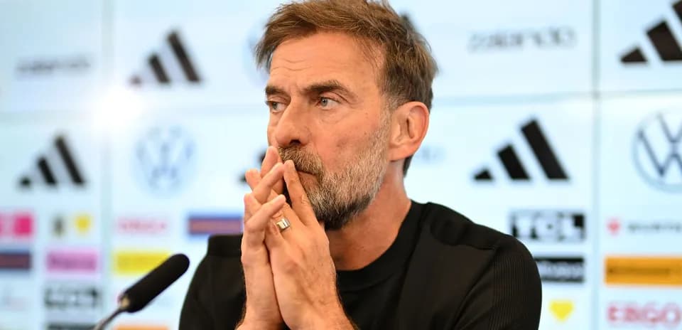 Entrenador en conferencia de prensa, manos entrelazadas