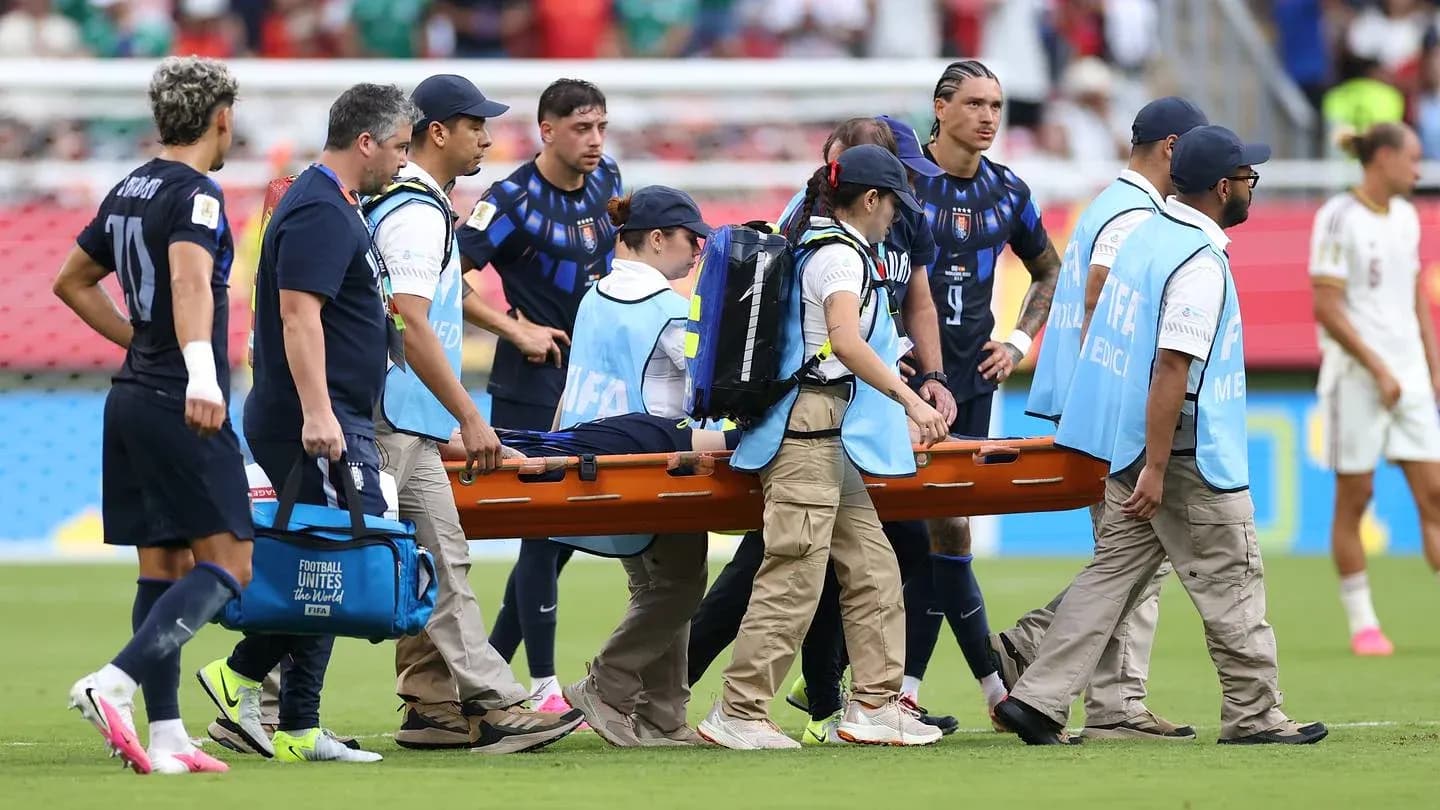 Jugadores observando mientras llevan a un jugador lesionado
