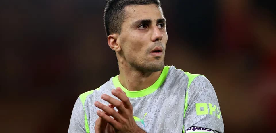 Jugador aplaudiendo con camiseta gris y verde