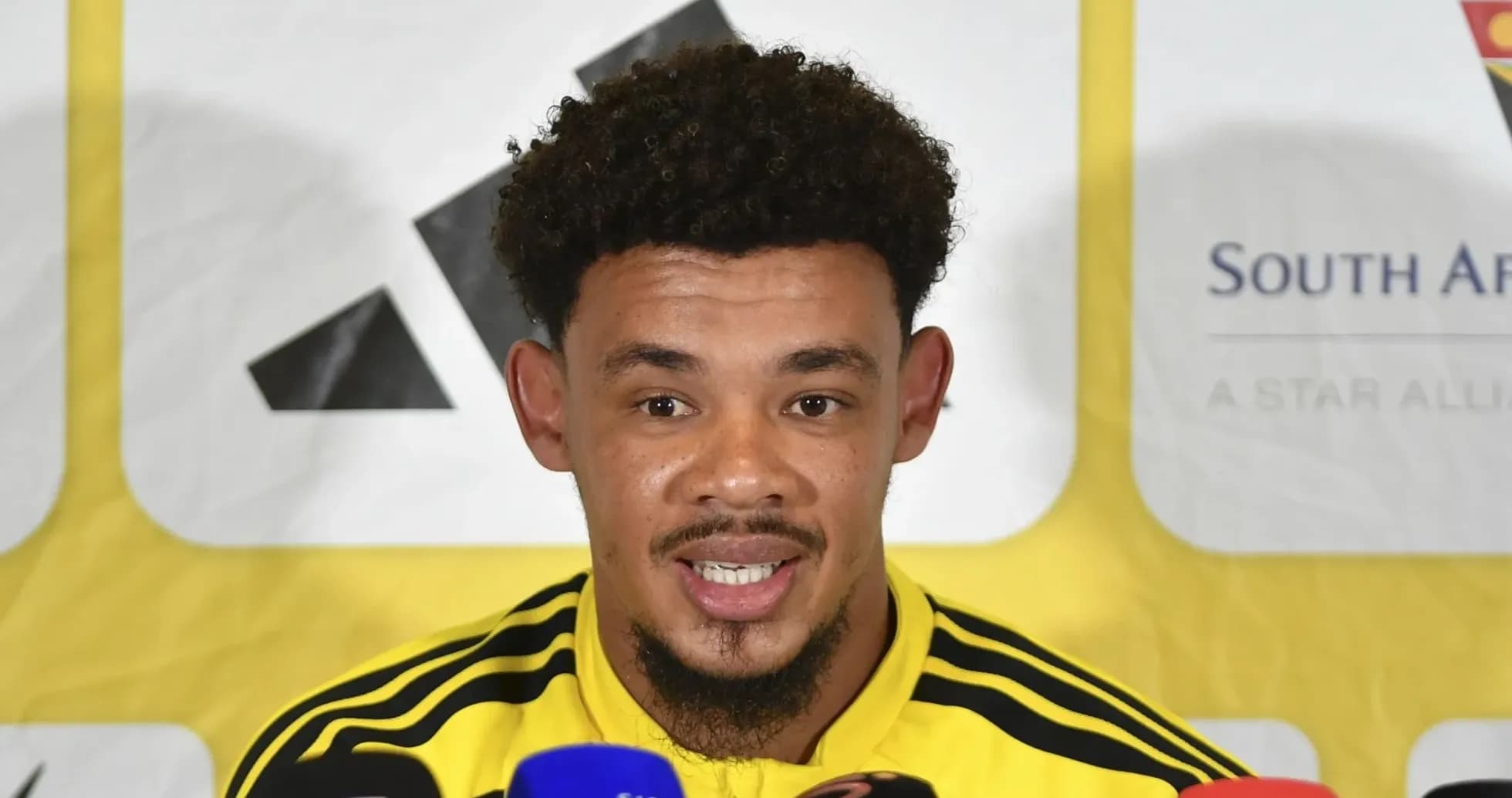 Jugador hablando en conferencia de prensa con micrófonos