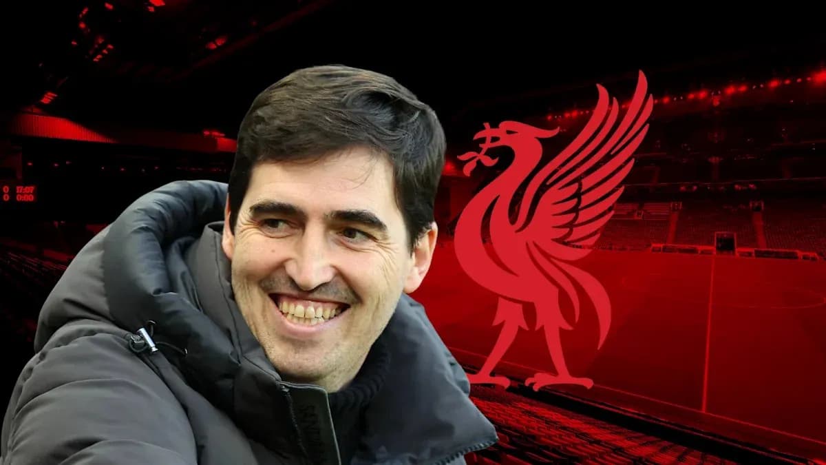 Entrenador sonriendo frente al logo de Liverpool