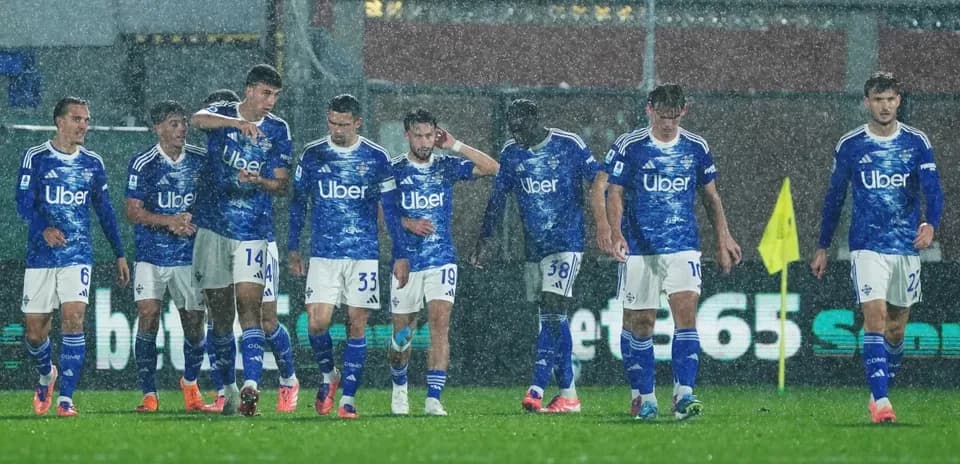 Jugadores de Como en partido bajo la lluvia