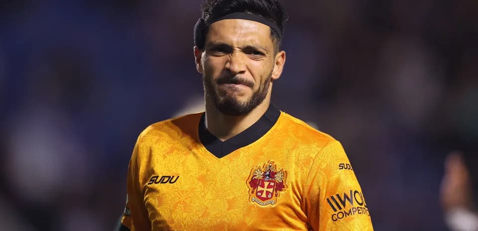 Jugador con camiseta naranja sonriendo en el campo