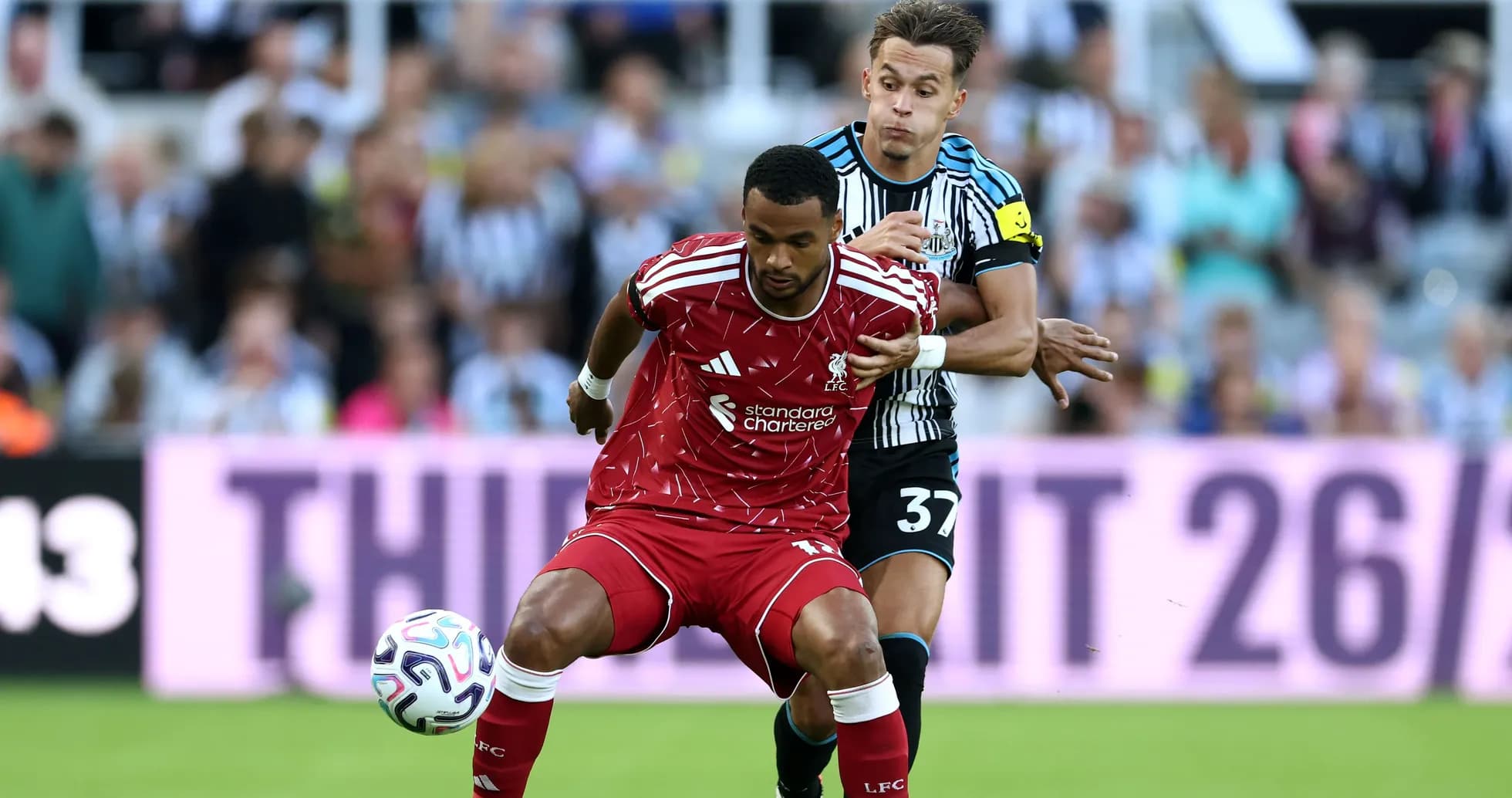 Jugador de Liverpool siendo desafiado por jugador de Newcastle