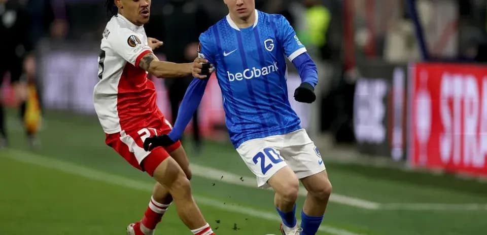 Jugador de KRC Genk driblando mientras es marcado