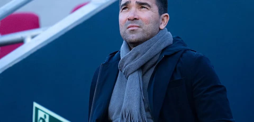 Hombre con abrigo y bufanda mirando hacia arriba