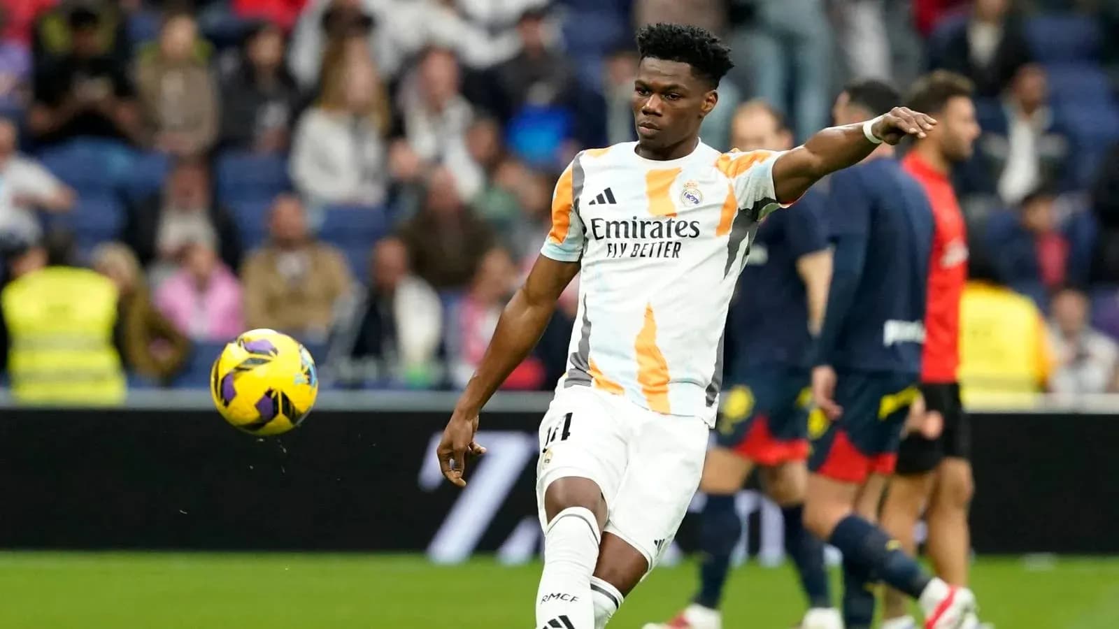 Jugador de Real Madrid pateando un balón en el campo