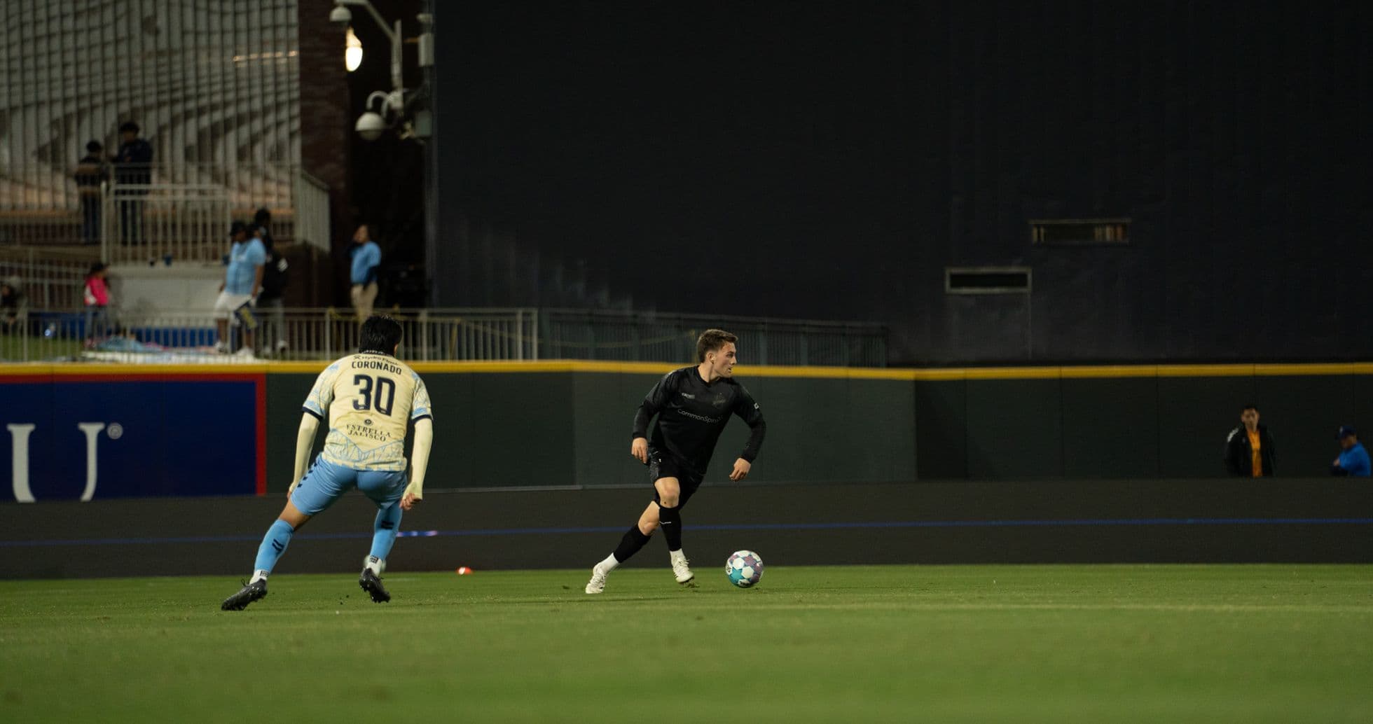 Jugador corriendo con el balón en el campo
