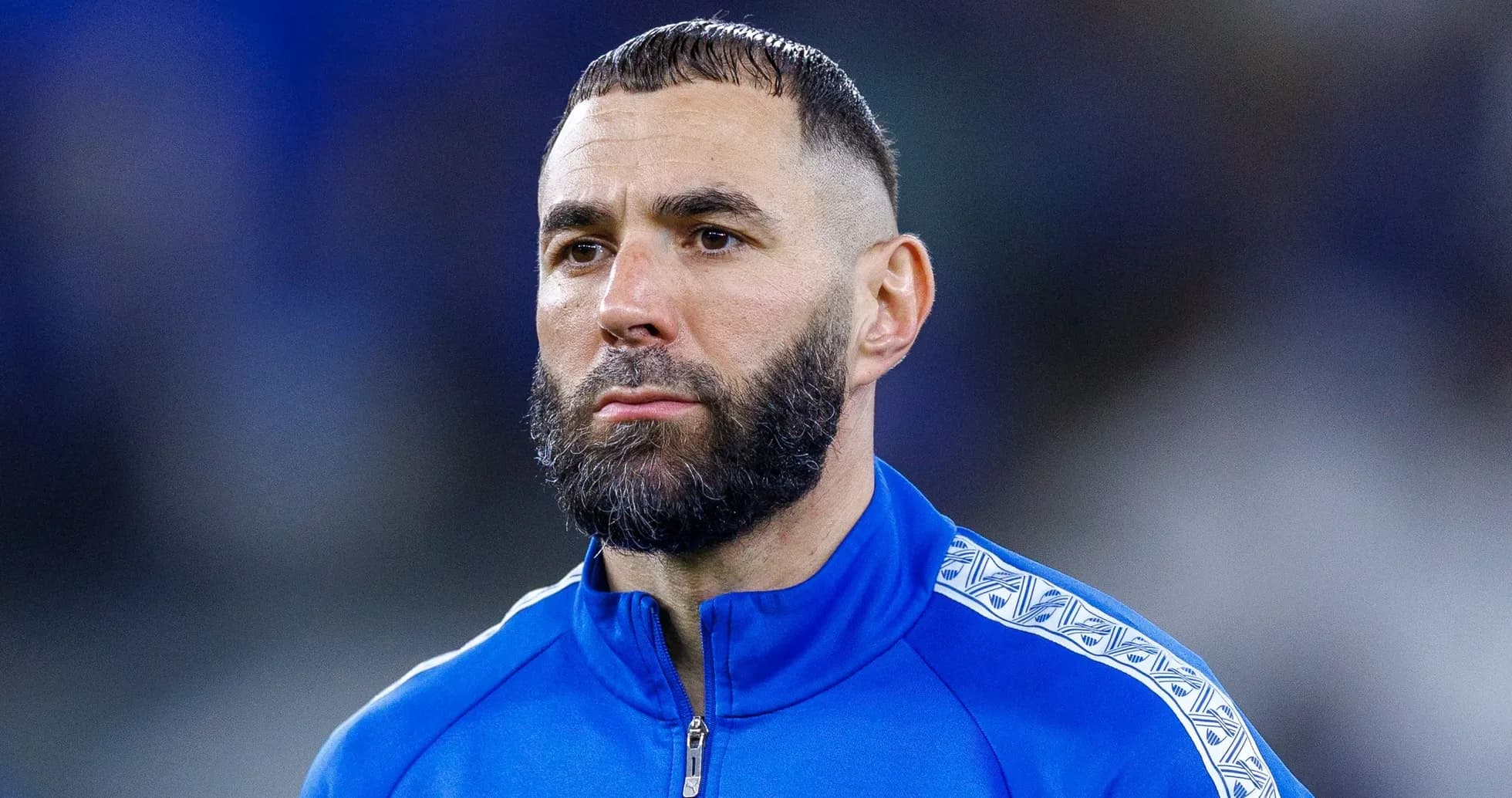 Jugador con chaqueta azul en el campo de fútbol