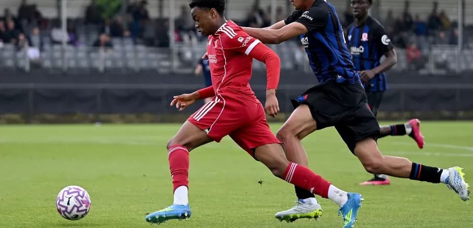 Jugador de Liverpool siendo perseguido por rival en partido