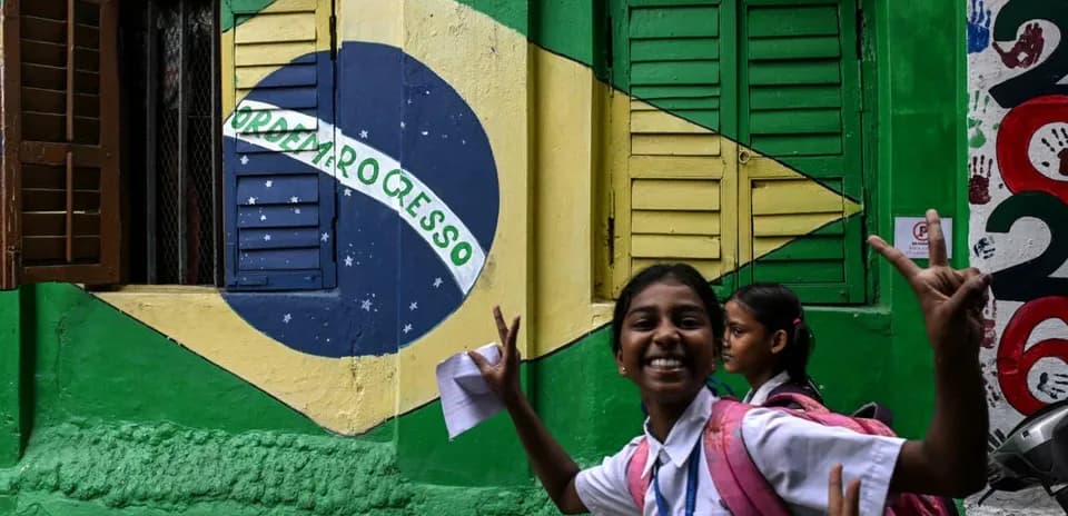 Niña sonriendo frente a mural de Brasil