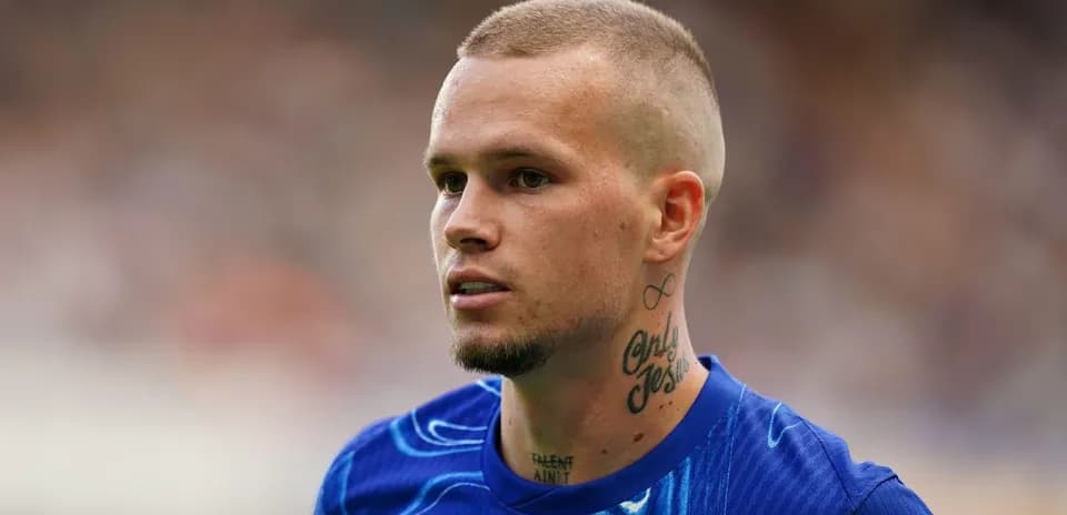 Jugador de fútbol con camiseta azul en el campo
