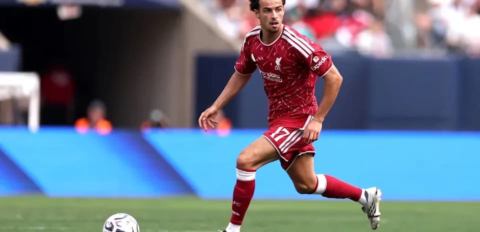 Jugador de Liverpool corriendo con el balón en campo