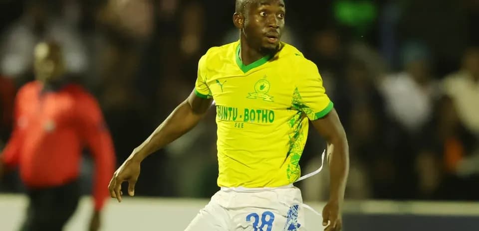 Jugador de fútbol corriendo con camiseta amarilla