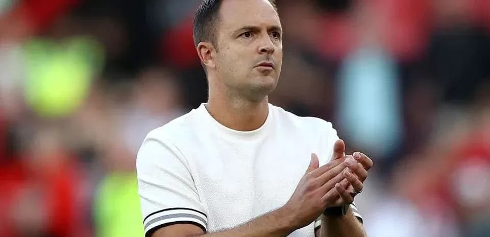 Entrenador aplaudiendo durante un partido de fútbol