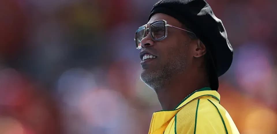 Ronaldinho con camiseta amarilla observando el partido