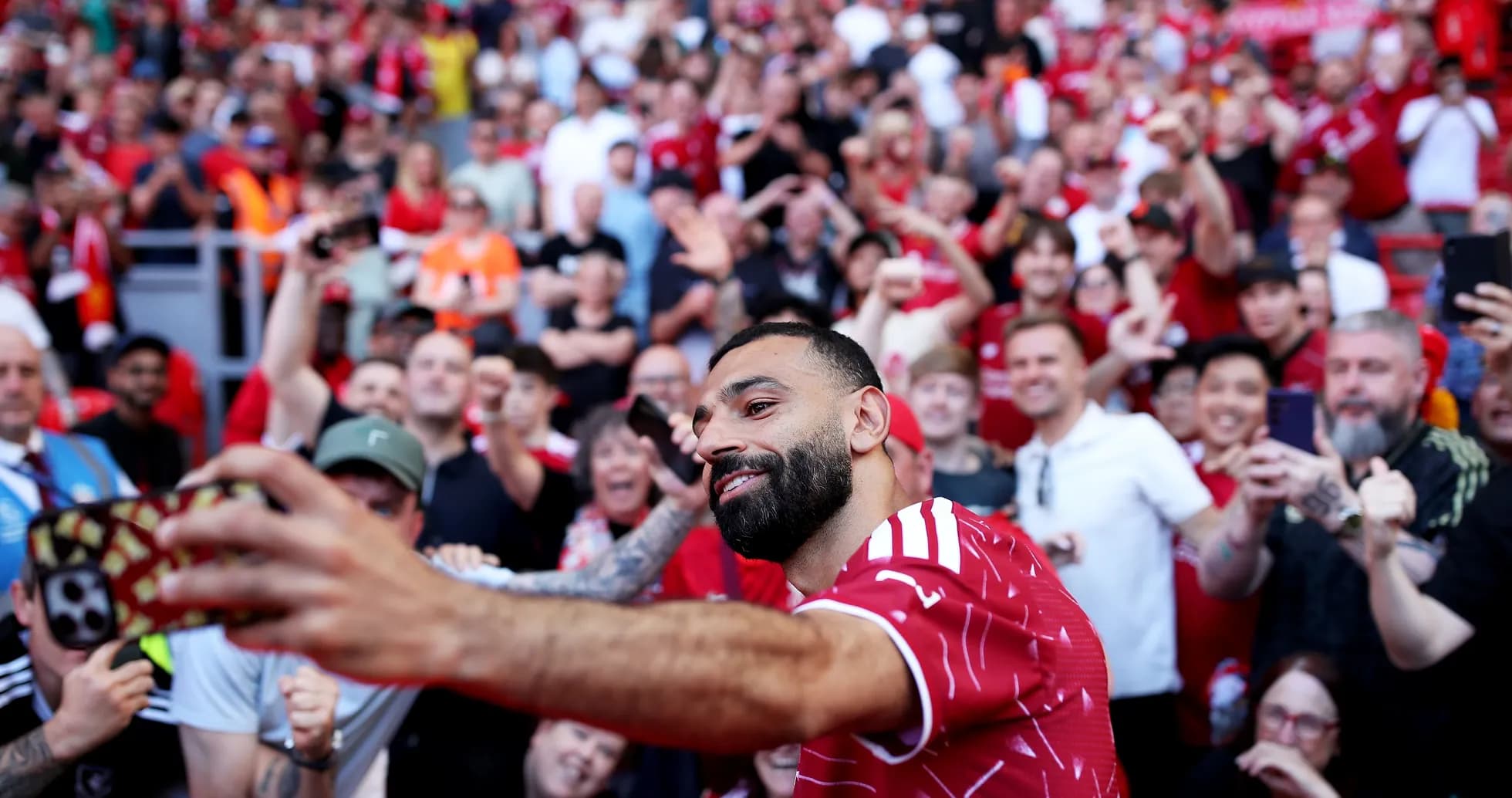 Jugador posando para selfie con aficionados en el estadio