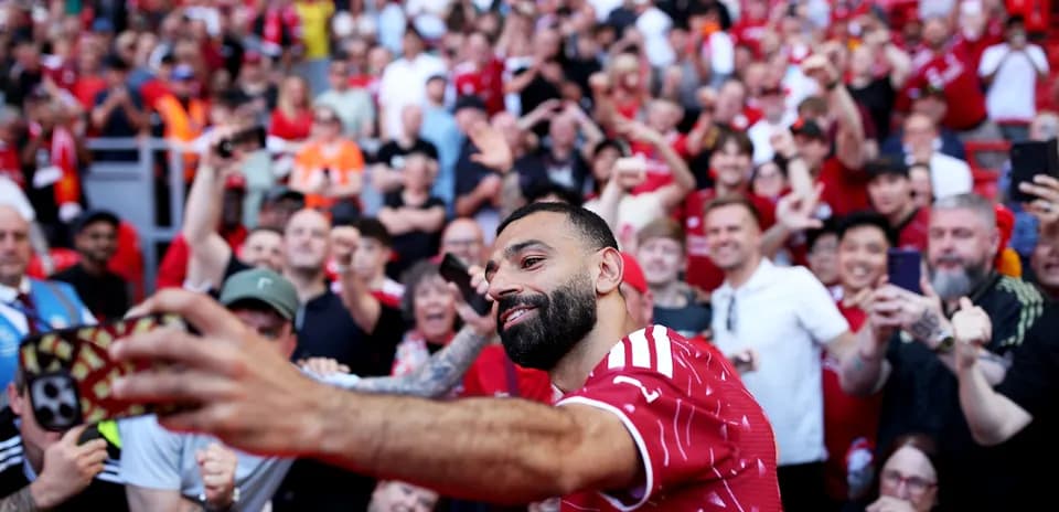 Jugador posando para selfie con aficionados en el estadio