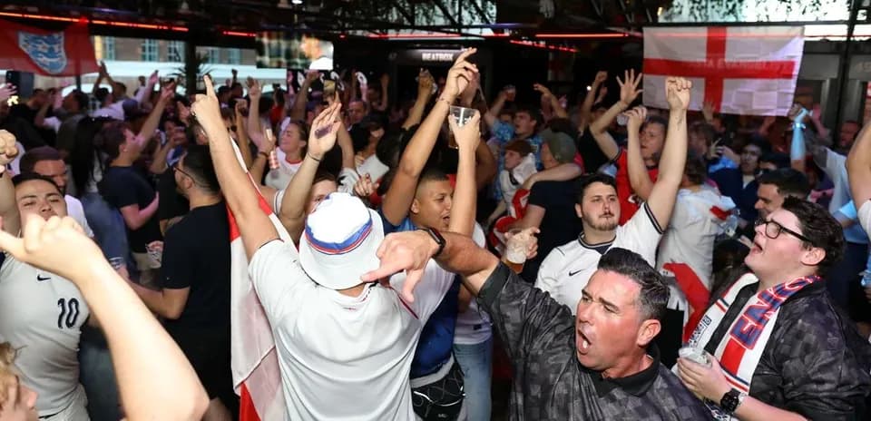 Aficionados animando en bar durante evento deportivo