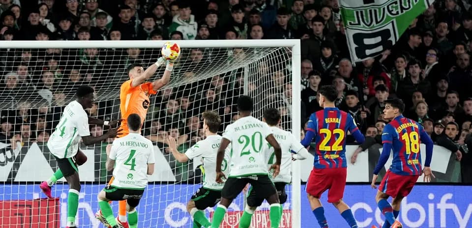 Portero atrapando el balón en el área de gol