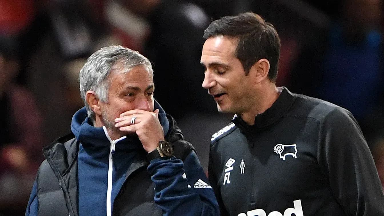 Entrenadores conversando durante un partido de fútbol
