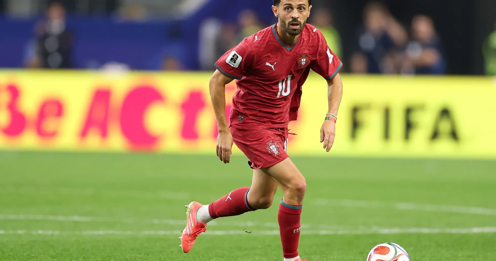 Jugador de Portugal corriendo con el balón en el campo