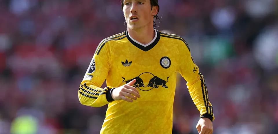 Jugador con camiseta amarilla corriendo en el campo