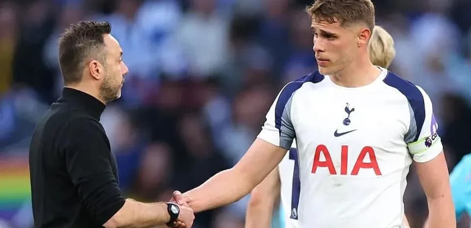 Entrenador y jugador de Tottenham estrechando manos