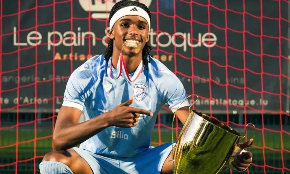Jugador sosteniendo un trofeo frente a la portería