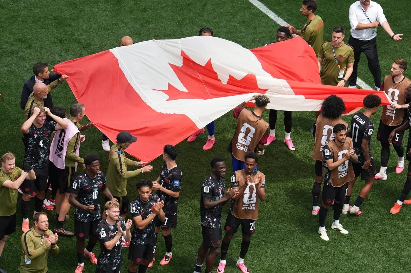 Jugadores de Canadá sosteniendo la bandera