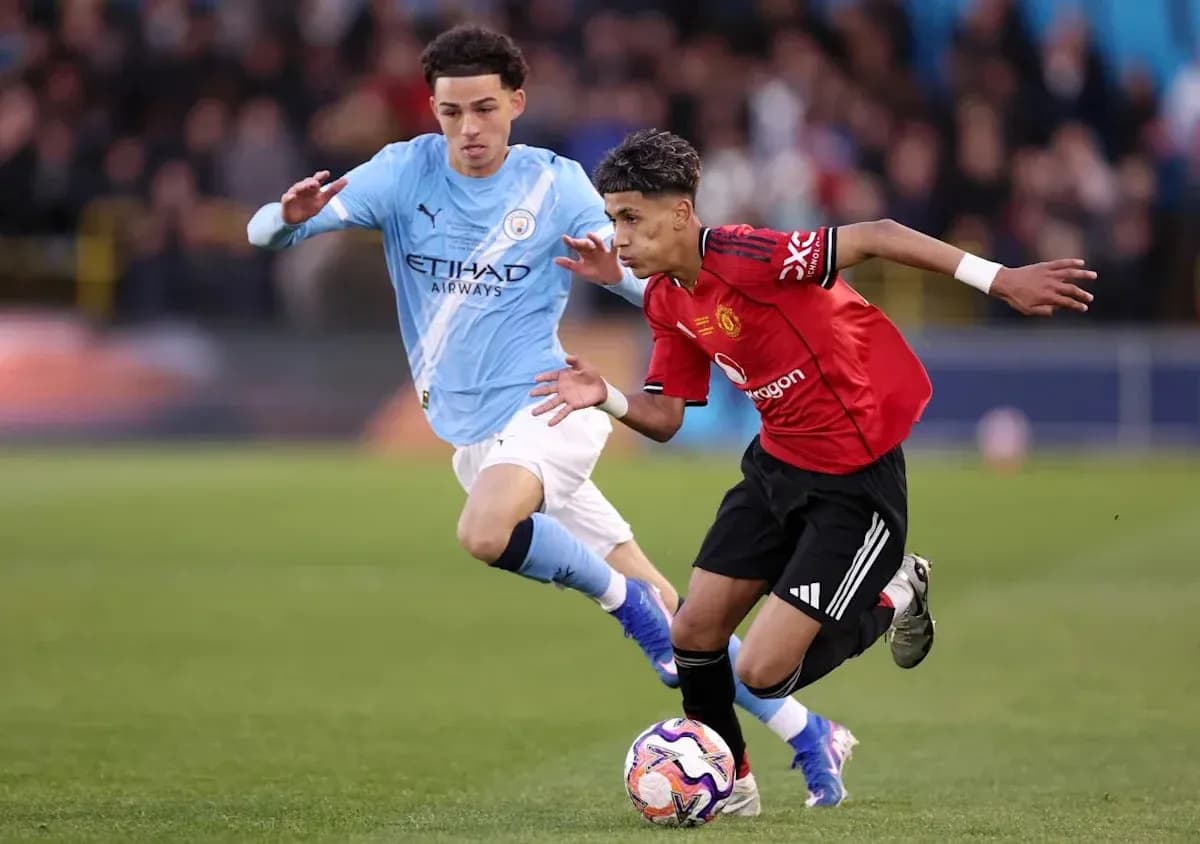 Jugador de Manchester United driblando a rival de Manchester City
