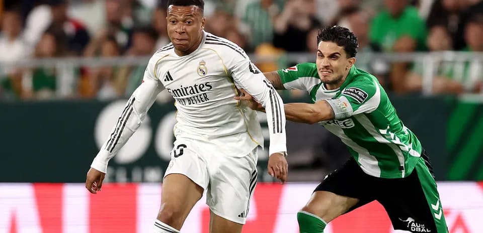 Jugador de Real Madrid corriendo mientras es marcado