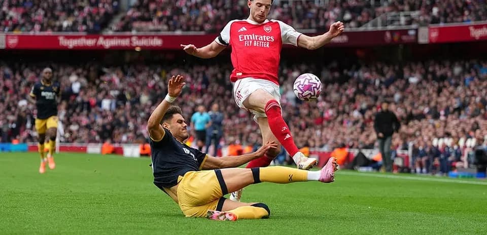 Un jugador de Arsenal esquivando a un oponente