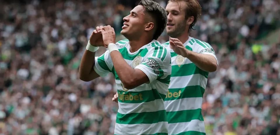 Jugador celebrando un gol con compañero en estadio
