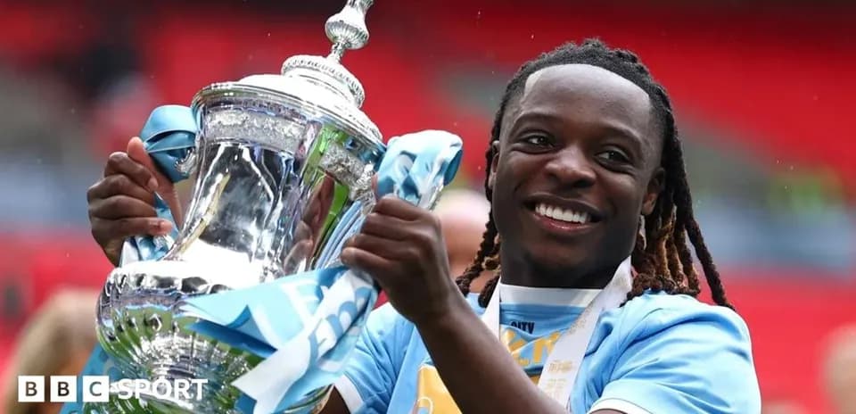 Jugador sosteniendo trofeo de la FA Cup en Wembley