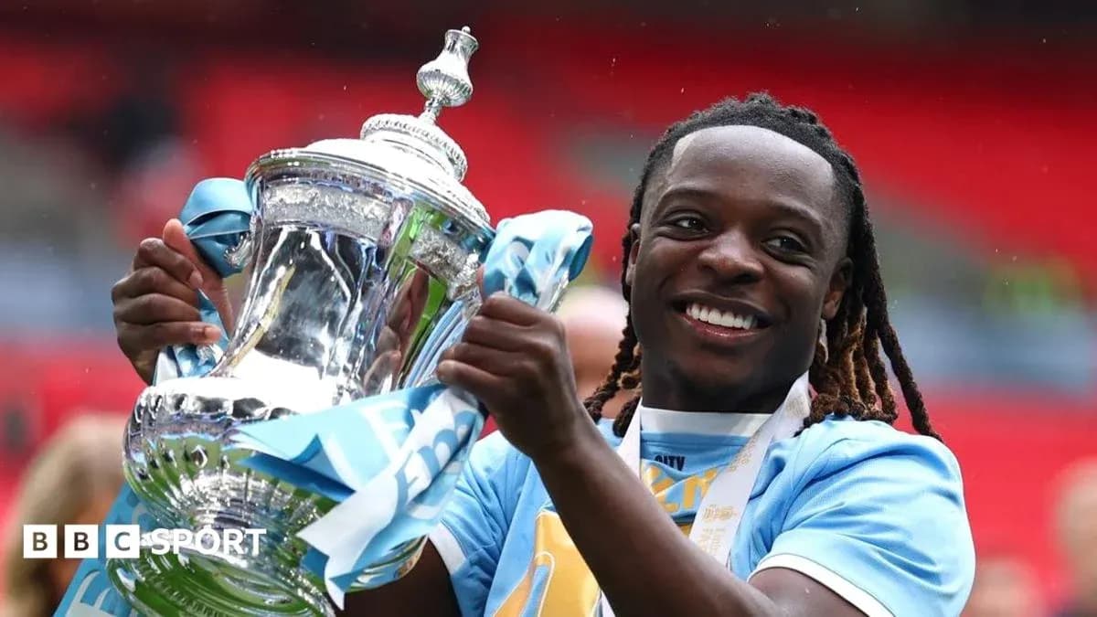 Jugador sosteniendo trofeo de la FA Cup en Wembley
