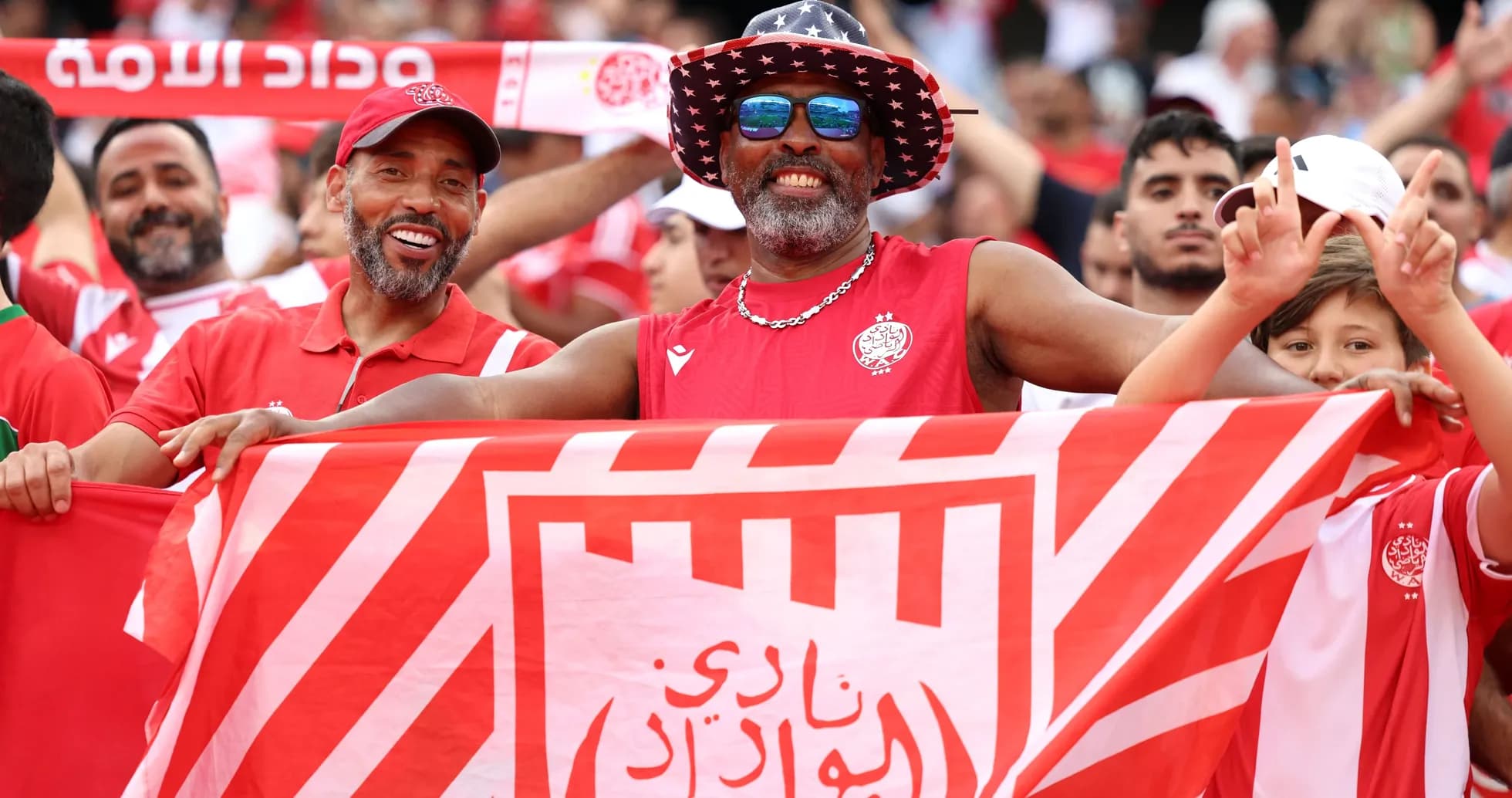 Aficionados sosteniendo una bandera de Wydad en el estadio