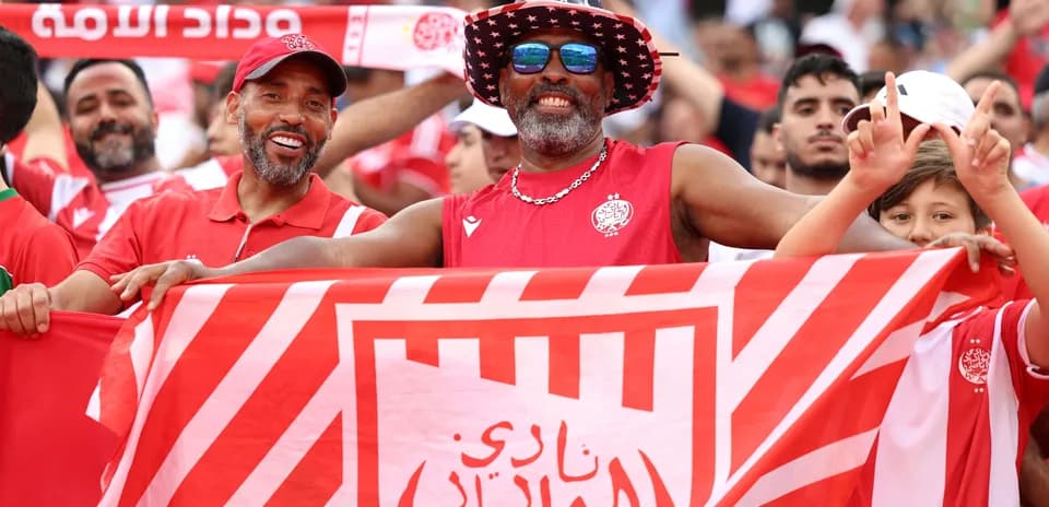 Aficionados sosteniendo una bandera de Wydad en el estadio