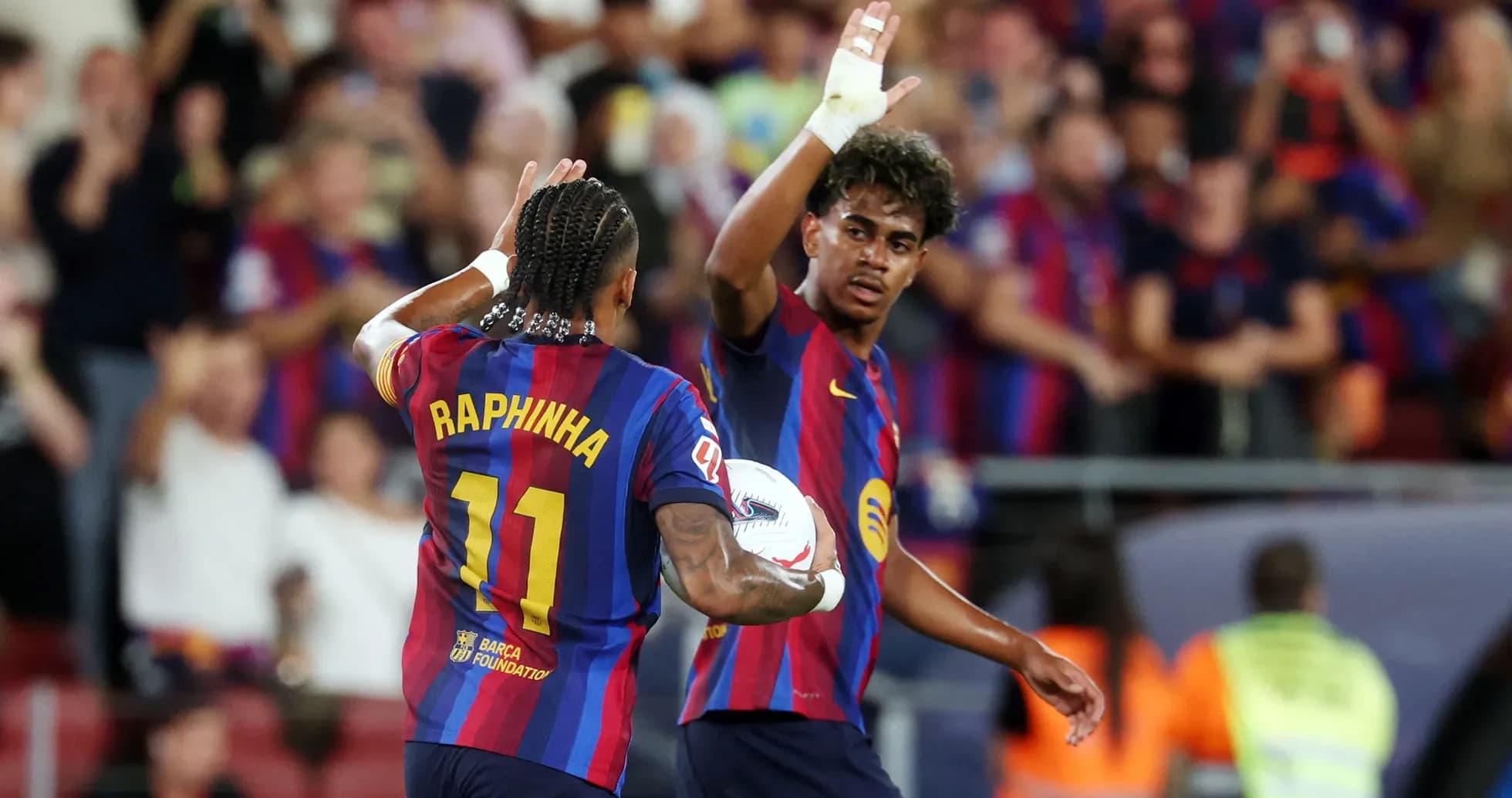 Raphinha y compañero celebrando en el campo