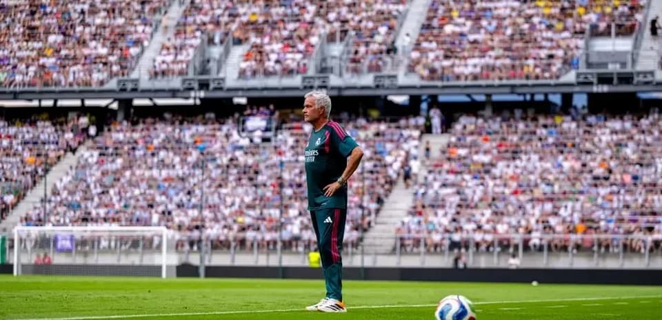 Entrenador de pie en el campo durante el partido