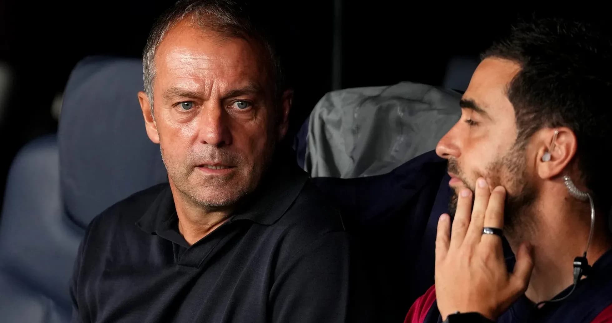 Entrenadores conversando en el banquillo durante partido