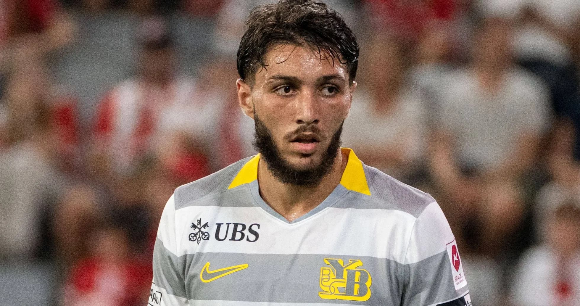 Jugador con camiseta gris y amarilla en el campo