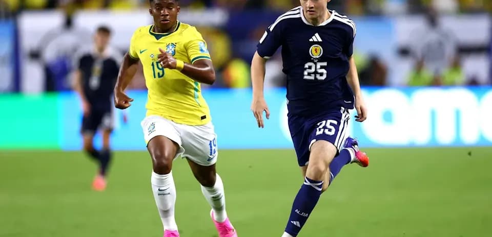 Jugador de Escocia corriendo con el balón, Brasil persiguiéndolo