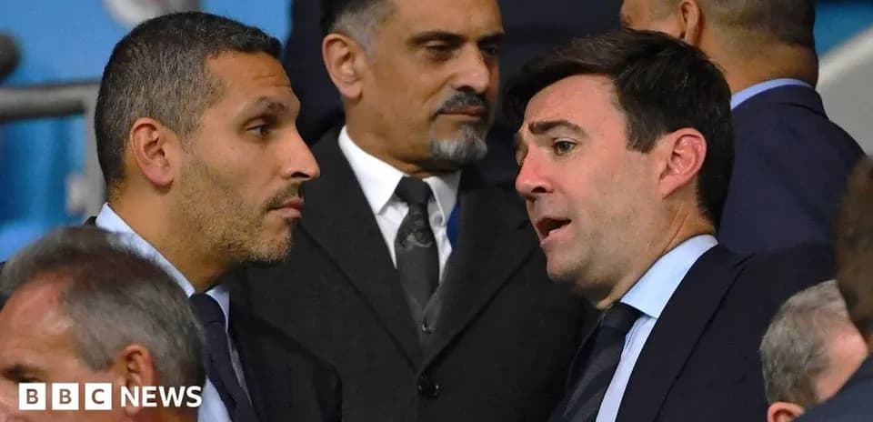 Dos hombres conversando en un evento deportivo