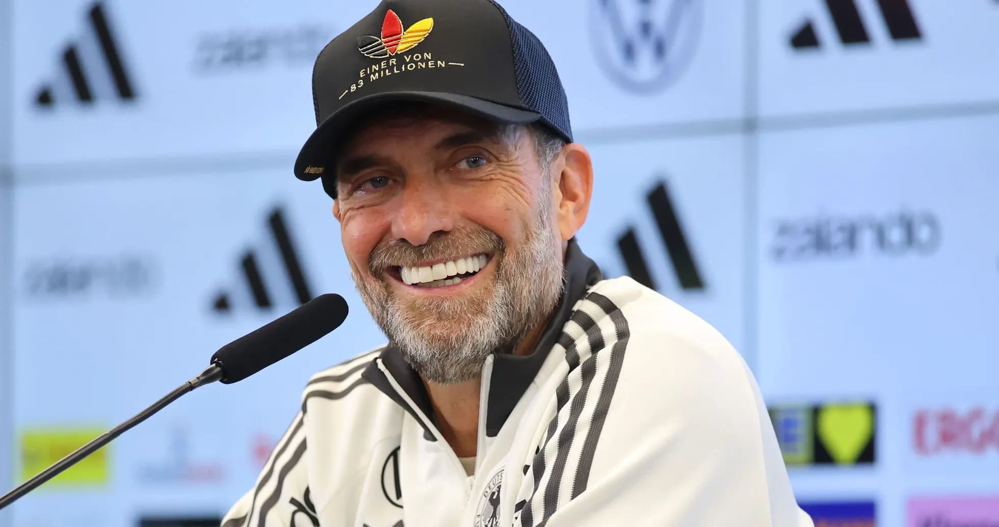 Entrenador sonriendo en rueda de prensa