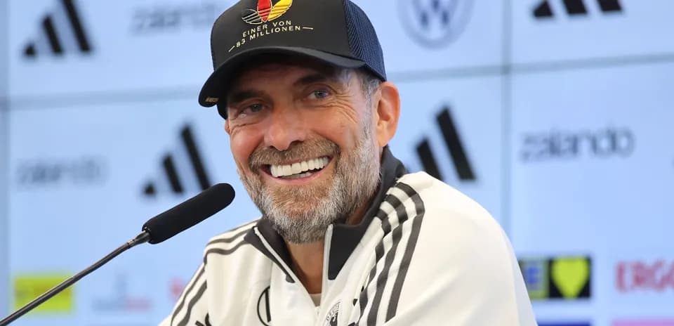 Entrenador sonriendo en rueda de prensa
