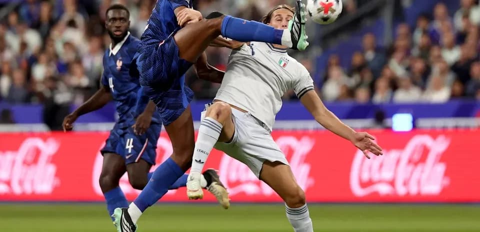 Jugador francés pateando el balón a jugador italiano