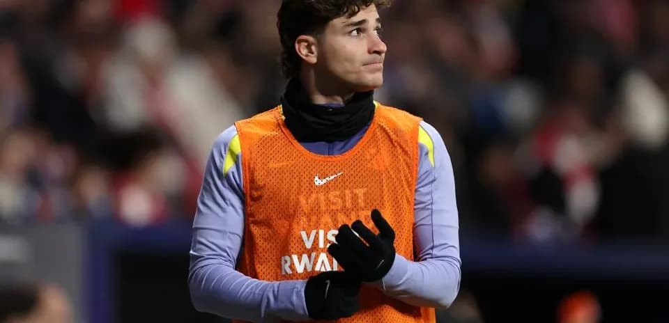 Jugador en el banquillo con chaleco de calentamiento